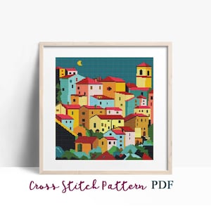 Può includere: Schema di punto croce di un villaggio colorato con un campanile di chiesa di notte. Le case sono di varie tonalità di giallo, arancione, rosso, blu e verde. Il cielo è blu scuro con una luna crescente.