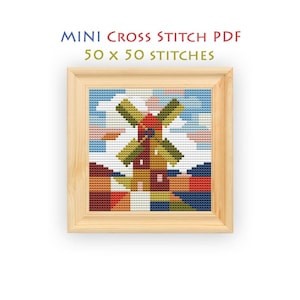 May include: A framed cross stitch pattern featuring a windmill in a landscape with red, green, and blue geometric shapes. The text above reads MINI CROSS STITCH PDF 50 x 50 STITCHES. The design is displayed within a light-colored wooden frame.