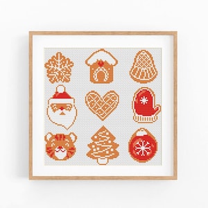 May include: A square cross-stitch pattern featuring nine holiday-themed icons arranged in a grid. The designs include a snowflake, a gingerbread house, a bell, a Santa Claus face, a heart, a red mitten, a tiger face, a tree, and a red ornament.