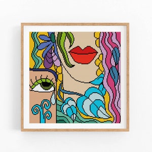 May include: A colorful abstract cross-stitch pattern featuring a woman's face with a bright red lip, green eye, and blue and yellow floral details.
