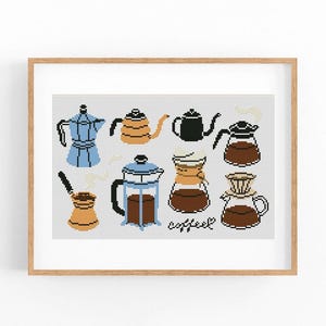 May include: A framed cross-stitch featuring various coffee makers in blue, orange, black, and brown. The word "coffee" is stitched in cursive. The image is set against a white background.