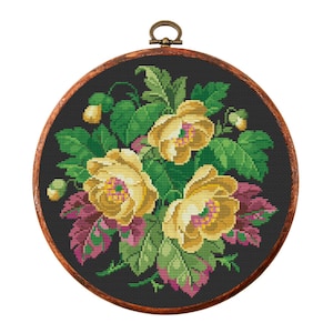 May include: A round embroidery hoop with a black background and a floral design. The flowers are yellow with green leaves and pink accents.