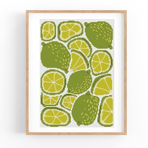 May include: A cross-stitch pattern featuring a colorful arrangement of limes and lime slices. The pattern is framed in a light wood frame.