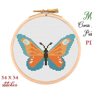 May include: A cross stitch pattern featuring a butterfly with orange wings and blue accents. The pattern is displayed in a wooden embroidery hoop and measures 54 x 34 stitches. The text "Mini Cross Stitch Pattern PDF" is displayed above the hoop.