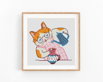 May include: Cross-stitch art of a ginger cat wearing glasses, pouring from a blue teapot into a mug. The cat is wearing a pink and white checkered shirt. The mug has a blue and white design. The artwork is framed in a wooden frame.