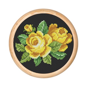 May include: A framed cross-stitch embroidery featuring a bouquet of yellow roses with green leaves on a black background.