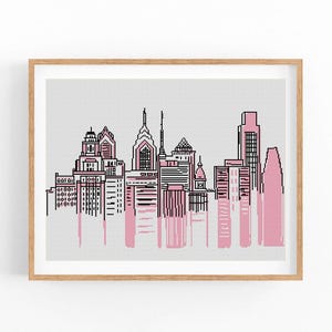 Op de afbeelding: Een zwart-witte lijntekening van de skyline van Philadelphia met roze aquarelwas achter de gebouwen.