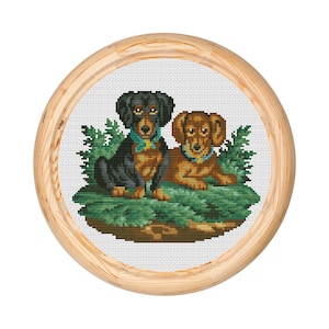 May include: Cross-stitch embroidery of two dachshund dogs sitting on a bed of green leaves. The dogs are wearing blue collars with tags. The dachshund on the left is black and brown, and the dachshund on the right is brown.