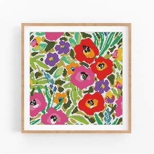 Può includere: Un'opera d'arte floreale a punto croce incorniciata con una vibrante serie di fiori. Il design include fiori rossi, rosa, viola e gialli con fogliame verde. L'opera è incorniciata in una cornice di legno naturale, creando un pezzo decorativo.