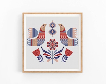 Könnte beinhalten: Ein gerahmtes Kreuzstichdesign mit zwei stilisierten Vögeln mit komplizierten Mustern in Rot, Blau und Beige. Das Design enthält florale Elemente in Rot, Rosa und Blau auf weißem Hintergrund. Der Rahmen ist hellbraun.
