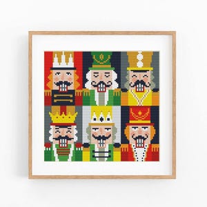 May include: A framed cross-stitch pattern featuring a grid of six stylised nutcracker figures. Each nutcracker is rendered in a pixelated style with distinct colour schemes including red, green, yellow, and blue, all wearing uniforms and crowns.