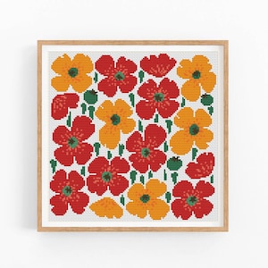 May include: Cross stitch pattern featuring a colorful floral design with red and orange flowers on a white background. The flowers are arranged in a grid pattern and are surrounded by green leaves.
