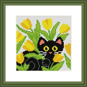 K&ouml;nnte beinhalten: Eine schwarze Katze mit gelben Augen sitzt in einem Feld mit gelben Tulpen. Die Katze hat wei&szlig;e Schnurrhaare und eine rosa Nase.