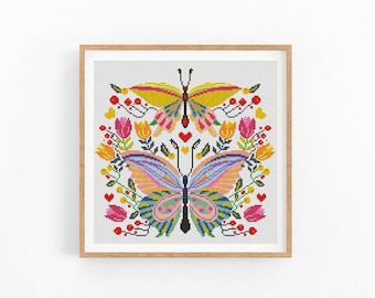 May include: Cross stitch pattern featuring two colourful butterflies surrounded by flowers and hearts. The butterflies have yellow, pink, blue, and green wings. The flowers are red, pink, yellow, and orange.