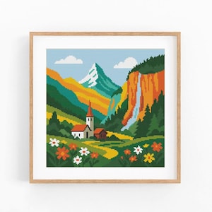 Puede incluir: Un paisaje en punto de cruz enmarcado que representa una escena de montaña con una iglesia, una cascada y flores coloridas. La obra de arte utiliza un estilo pixelado con tonos de verde, naranja, amarillo y azul. El marco es de madera marrón claro.