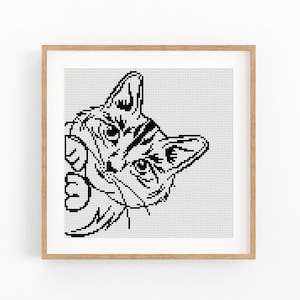 Peut inclure: Motif de point de croix noir et blanc d'un chat qui regarde d'un coin. Le chat a un motif rayé sur sa fourrure et regarde directement le spectateur.
