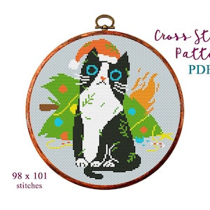 May include: Cross stitch pattern PDF of a black and white cat wearing a Santa hat and sitting in front of a green Christmas tree with colorful ornaments. The pattern is 98 x 101 stitches.