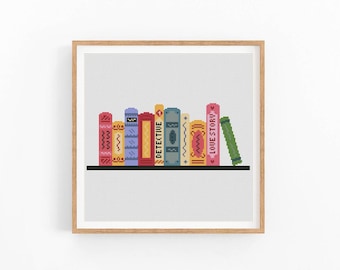 May include: A framed print showing a row of colourful, stylised books on a black shelf. The books have different designs and colours, with one labelled "DETECTIVE" and another "LOVE STORY". The background is a light grey grid.