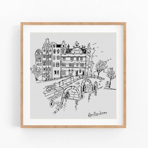 Op de afbeelding: Een zwart-wit lijntekening van Amsterdamse gebouwen, een brug en bomen, in een houten lijst. Het woord "Amsterdam" is in cursiefschrift rechtsonder in de afbeelding geschreven.