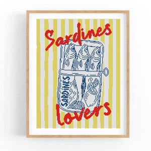 Pode incluir: Impressão emoldurada com uma ilustração azul e branca de uma lata de sardinhas, contendo peixes, sobre um fundo listrado amarelo e branco. A inscrição vermelha diz "Sardines Lovers".