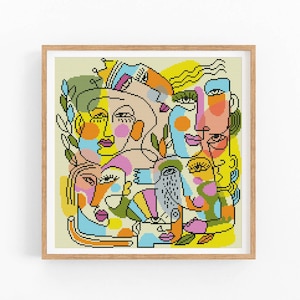 May include: Abstract cross-stitch art print featuring a collage of stylized faces in various colors, including yellow, orange, pink, and blue. The artwork is framed in a light brown wooden frame, adding a touch of warmth to the piece.