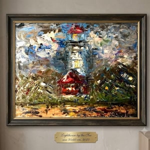 Puede incluir: Una pintura al óleo en un marco de madera oscura que representa un faro junto al mar con pinceladas gruesas y texturizadas en tonos azul, blanco, rojo y verde. Una placa dorada bajo el marco dice Lighthouse by the Sea, 30x40 cm, 2023.