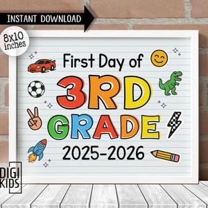 以下が含まれることがあります： 白いフレームのサインボードで、罫線入りの紙の背景に「First Day of 3RD GRADE 2025-2026」という文字が書かれています。赤い車、サッカーボール、ピースサイン、ロケット、黄色いスマイリーフェイス、緑の恐竜、稲妻、鉛筆などのカラフルなグラフィックが描かれています。