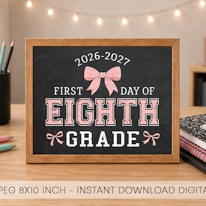 May include: A rectangular chalkboard sign in a wooden frame featuring the text 2026-2027 FIRST DAY OF EIGHTH GRADE in white and pink lettering with pink bow illustrations. The sign is displayed on a desk with pencils, notebooks, and a plant.