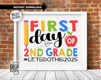May include: A white framed sign featuring the text FIRST DAY OF 2ND GRADE #LETSDOTHIS2025 in colorful lettering. The design includes a yellow pencil, a small black and white paper airplane, and a red apple icon on a white background.