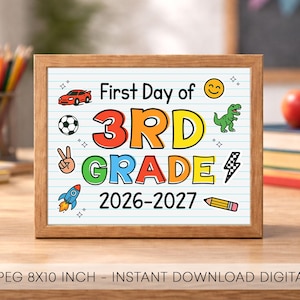 Könnte beinhalten: Ein gerahmtes Schild mit weißem, liniertem Hintergrund und dem Text First Day of 3RD GRADE 2026-2027. Das Design enthält bunte Illustrationen eines roten Autos, eines Fußballs, eines Friedenszeichens, einer Rakete, eines Smileys, eines Dinosauriers und eines Bleistifts.
