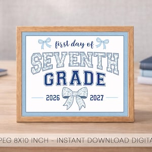 May include: A rectangular wooden frame containing a white sign with blue text that reads first day of SEVENTH GRADE 2026 2027. The design features blue bows and floral patterns within the letters. The sign measures 8 by 10 inches as indicated.