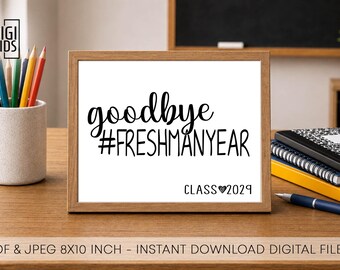 May include: A framed print with the words "goodbye #FRESHMANYEAR CLASS 2029" in black script. The print is on a wooden desk with pencils, notebooks, and a pen. The print is 8x10 inches.