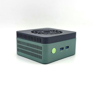 May include: A small, green and black computer with a fan on top. The front of the computer has a green power button and two USB ports. The computer is box-shaped and has ventilation slots on the sides.