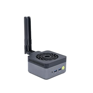 Peut inclure: Un mini-ordinateur compact de forme carrée avec une finition gris foncé et un dessus noir doté d'un ventilateur circulaire. Il comprend deux antennes noires verticales, deux ports USB bleus, une prise casque et un bouton d'alimentation vert.
