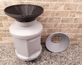 May include: A gray plastic container with a black funnel on top. The container has the text "Franklin's Arsenal" printed on the side. There is a second gray funnel lying on the counter.