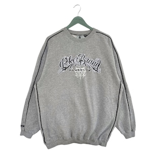 May include: A gray sweatshirt with black trim and the text "Joker Brand Classic" in a stylized font.