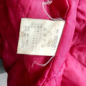 May include: A white tag with black text detailing the size, fabric composition, and care instructions for a jacket. The tag reads "NO. 693021 WDKROB Quality Display Outer Fabric: Nylon 100% Lining: Polyester 100% Jersey: Acrylic 100% SIZE Chest 84-98cm Height: 160-180cm F(L)"