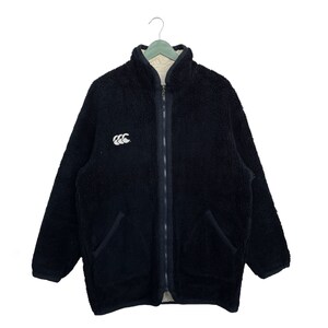 May include: A black fleece jacket with a zip fastening and a white logo on the left chest. The jacket has two pockets on the front.