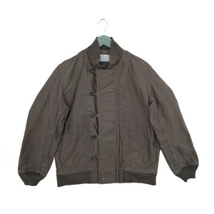 May include: A brown bomber jacket with a button closure and a ribbed collar and cuffs.