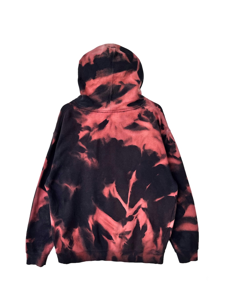 May include: A red and black tie-dye hoodie with a drawstring hood.