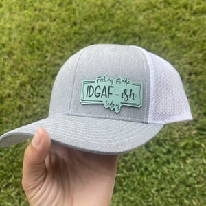 May include: Gray and white trucker hat with a green patch that says "Feeling Kinda IDGAF - ish today".