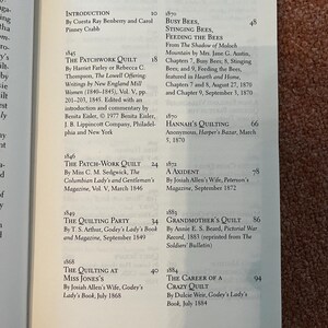 以下が含まれることがあります： 目次が表示された開いた本。 「The Patchwork Quilt」や「Busy Bees, Stinging Bees, Feeding the Bees」などのタイトルが記載されています。 テキストはクリーム色のページに黒色で表示されています。