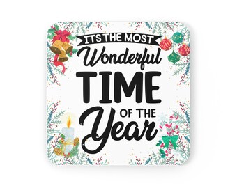 Puede incluir: Posavasos cuadrado blanco con un diseño navideño. Presenta el texto "It's the most Wonderful Time of the Year" con ilustraciones festivas de campanas, adornos, bastones de caramelo y una vela.