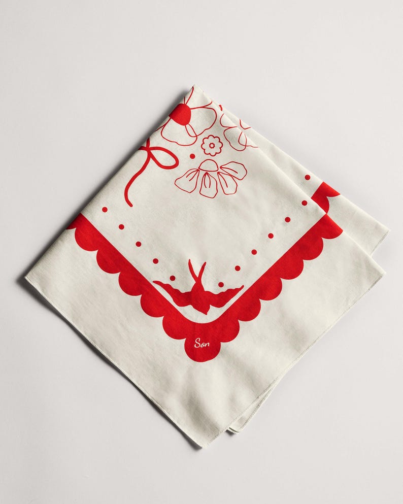 Puede incluir: Pa&ntilde;uelo cuadrado color crema con borde festoneado rojo y dise&ntilde;os florales y de p&aacute;jaros. El pa&ntilde;uelo presenta un lazo rojo, flores, puntos y un p&aacute;jaro. La palabra "Son" est&aacute; impresa en rojo.