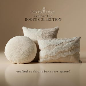 May include: Three cream-coloured textured cushions. One is round, the others are rectangular with a layered design. The image includes the text "kanochoo explore the ROOTS COLLECTION" and "crafted cushions for every space!"