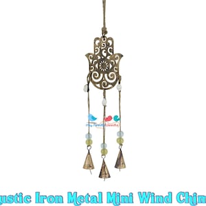 May include: A rustic iron metal mini wind chime featuring a hamsa hand design with cut-out details. The chime has four bells and is adorned with beads and small bird charms.