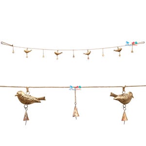 May include: Decorative bird garland featuring small, gold-colored bird figurines hanging from a natural-colored rope. Each bird has a small bell suspended below. The garland is designed for decorative purposes.