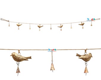 May include: Decorative bird garland featuring small, gold-colored bird figurines hanging from a natural-colored rope. Each bird has a small bell suspended below. The garland is designed for decorative purposes.