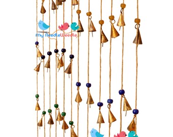 May include: A string of gold bells with blue and green beads hanging from a natural twine. The bells are arranged in a staggered pattern, creating a visual rhythm. The twine is tied at the top, suggesting a hanging decoration.