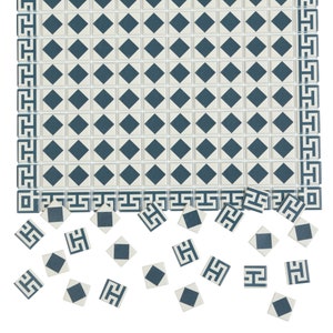 Puede incluir: Una lámina de azulejos con un diseño geométrico de patrón blanco y azul. La lámina se rompe en azulejos individuales, algunos de los cuales están dispersos debajo.